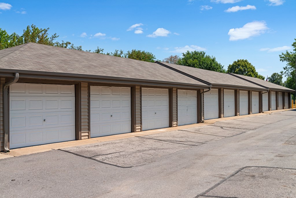a row of garages with white doors and roofs