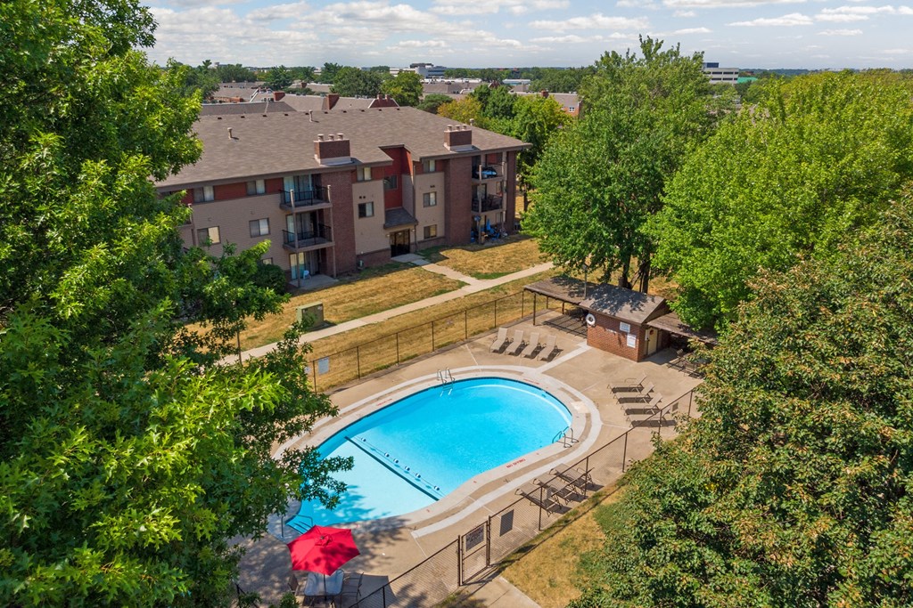 an aerial view of a swimming pool in front of an apartment building