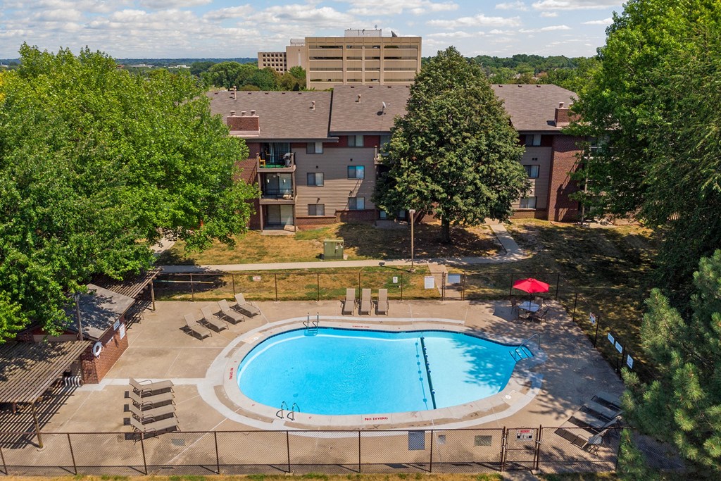 an aerial view of a swimming pool with a building in the background