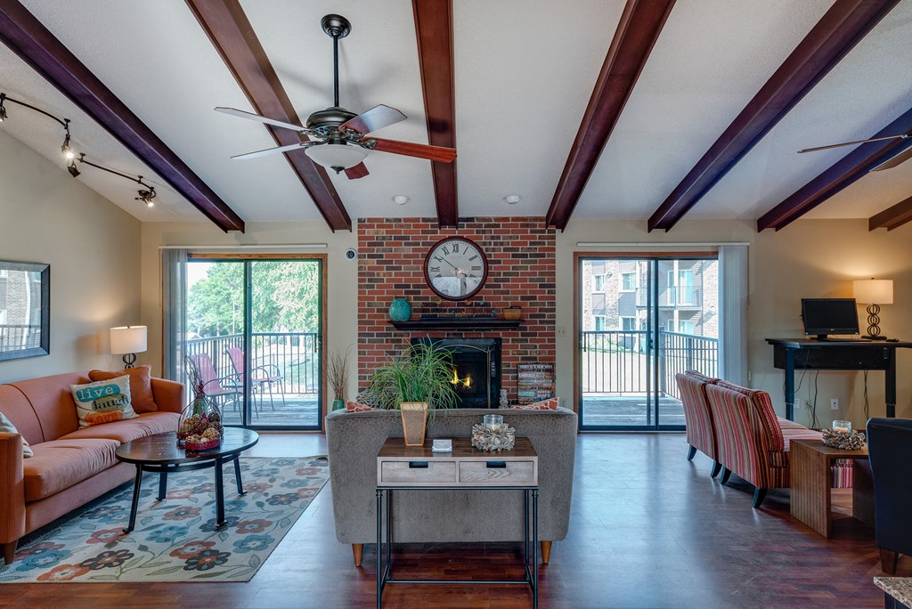the view of a living room with a fireplace and a ceiling fan