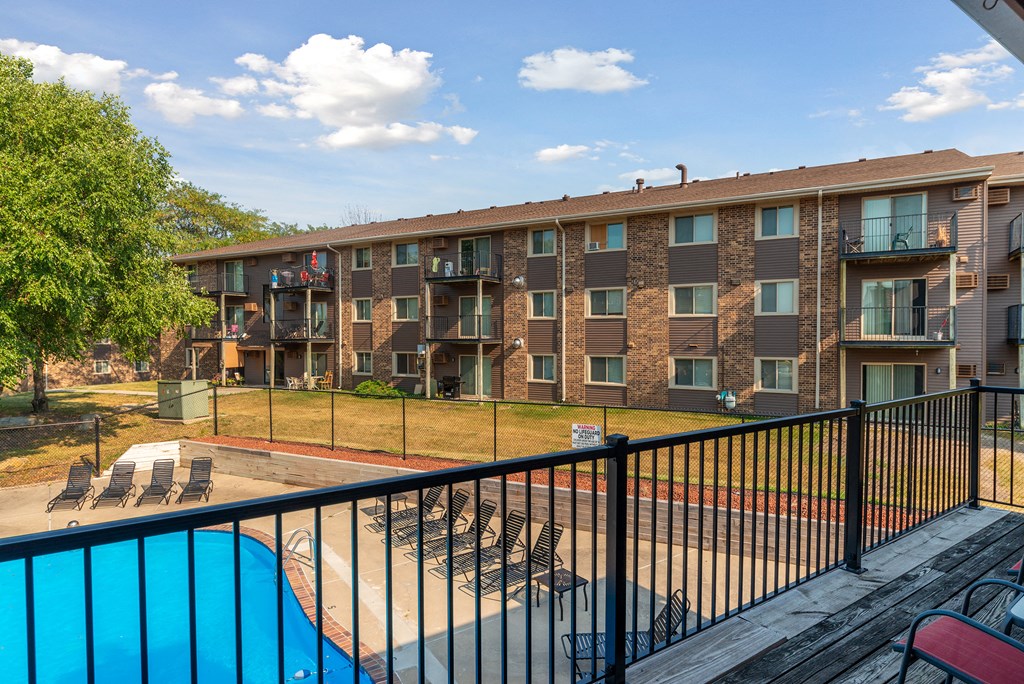 a balcony with a pool and an apartment building
