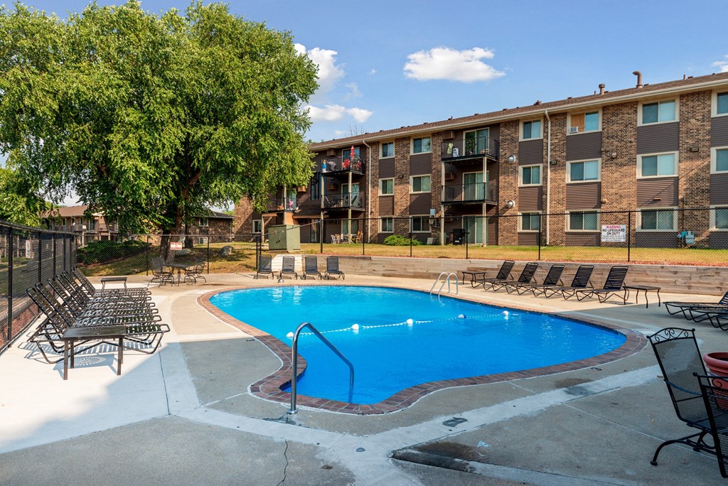 our apartments have a large pool and a patio with chairs