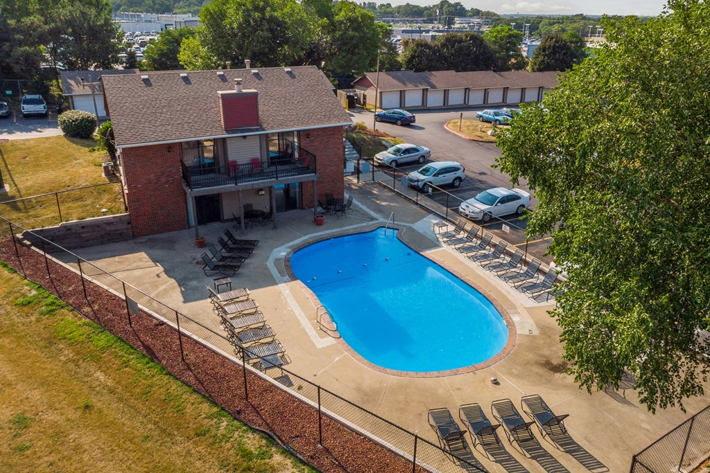 an aerial view of a swimming pool in front of a house