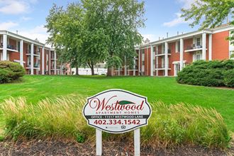 our apartments are located in a quiet neighborhood with a green lawn and sign