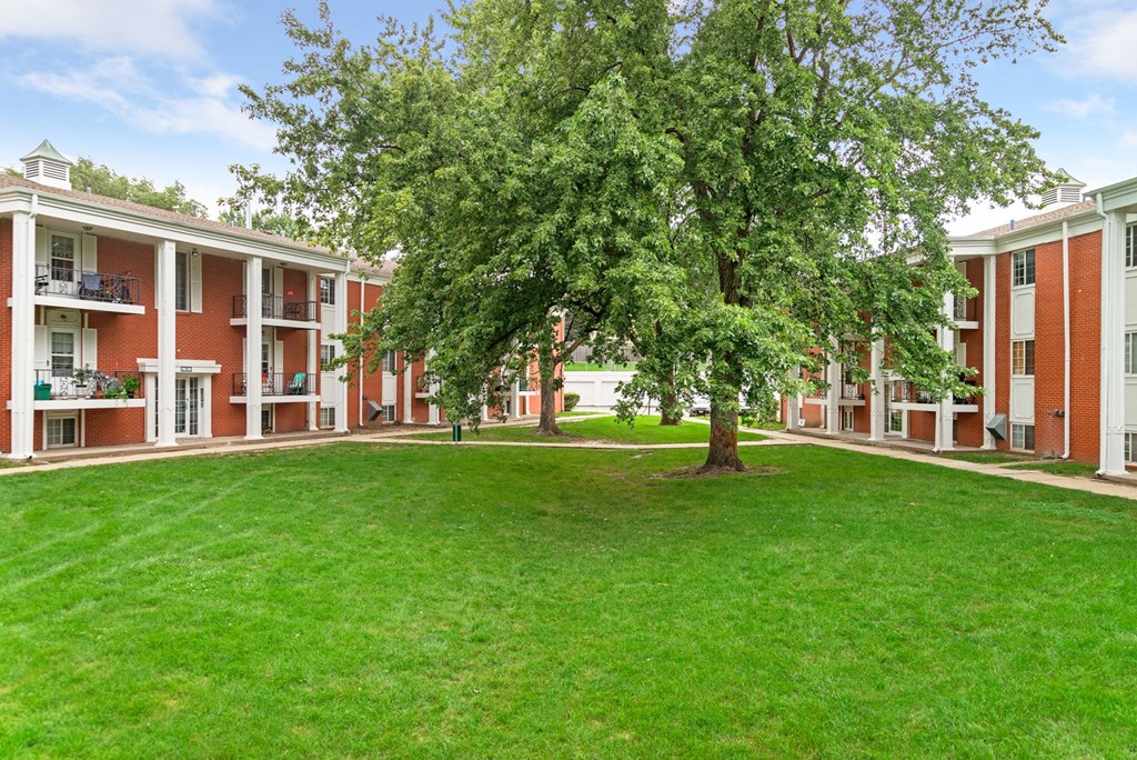 a green lawn in front of an apartment building