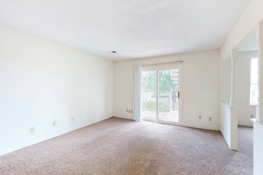 an empty living room with a door to a patio