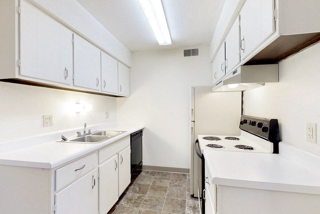 a kitchen with white cabinets and a stove and a sink