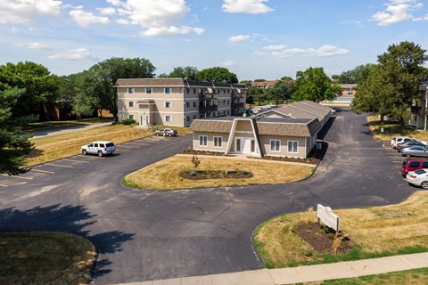 an aerial view of an apartment complex with cars parked in a parking lot