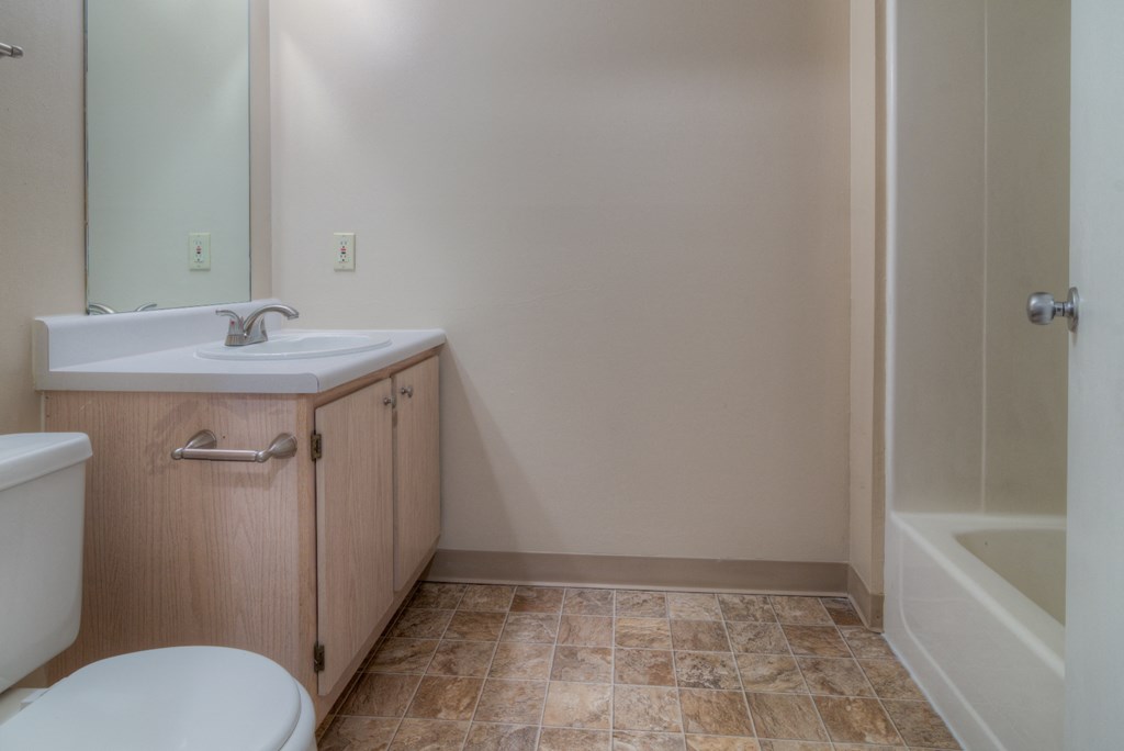 an empty bathroom with a sink toilet and shower