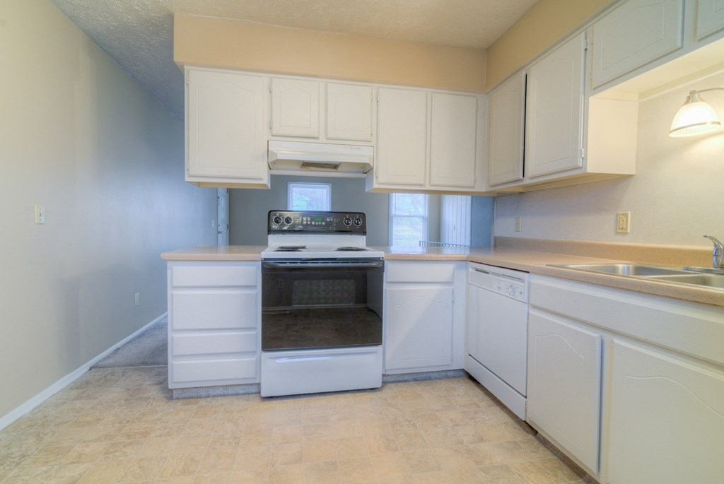 a kitchen with white cabinets and a stove and a sink