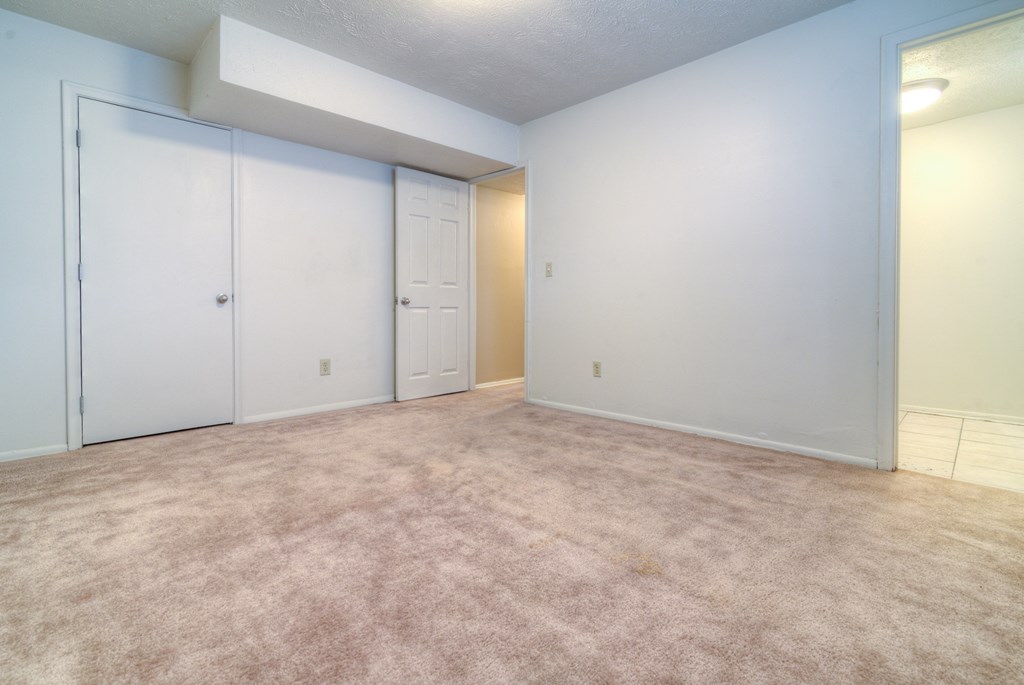 an empty living room with white walls and a carpet