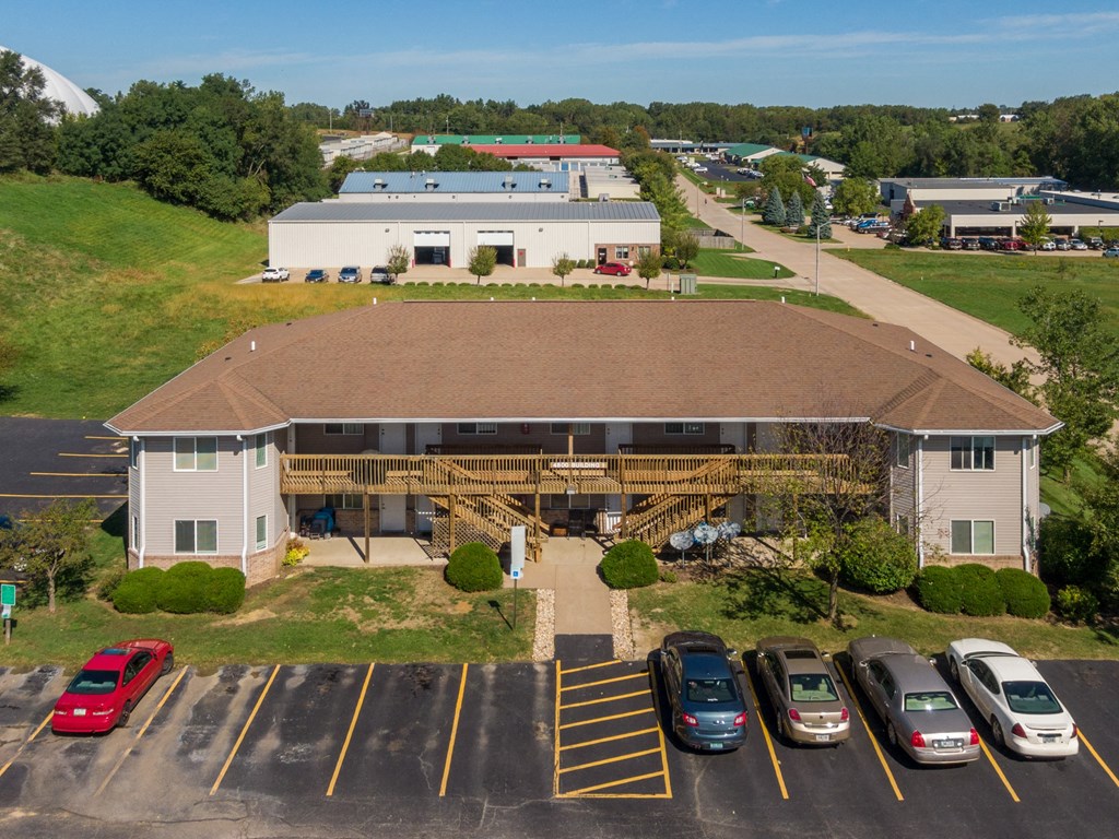 an aerial view of a building with cars parked in a parking lot