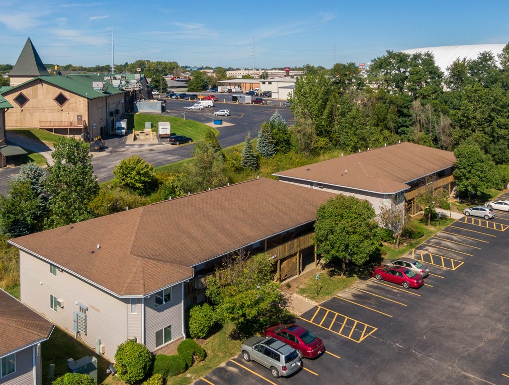 an aerial view of a building with cars parked in a parking lot