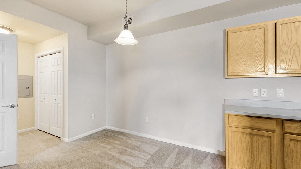 an empty kitchen with wooden cabinets and a white door