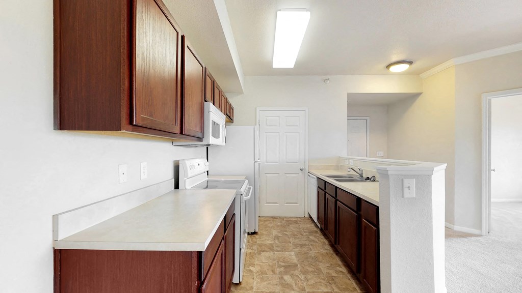 a renovated kitchen with white counter tops and wooden cabinets