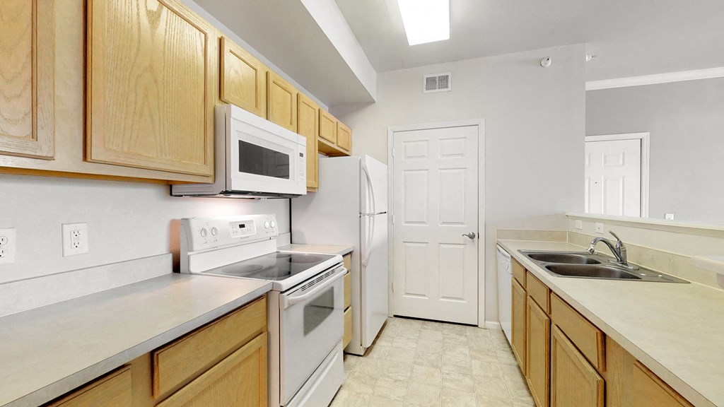 a kitchen with white appliances and wooden cabinets