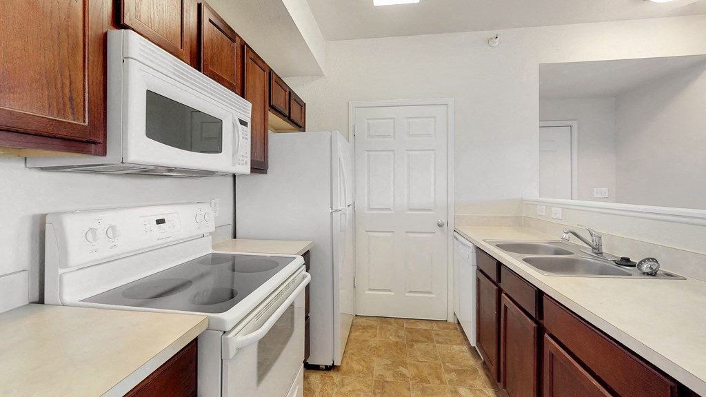 a kitchen with white appliances and wooden cabinets