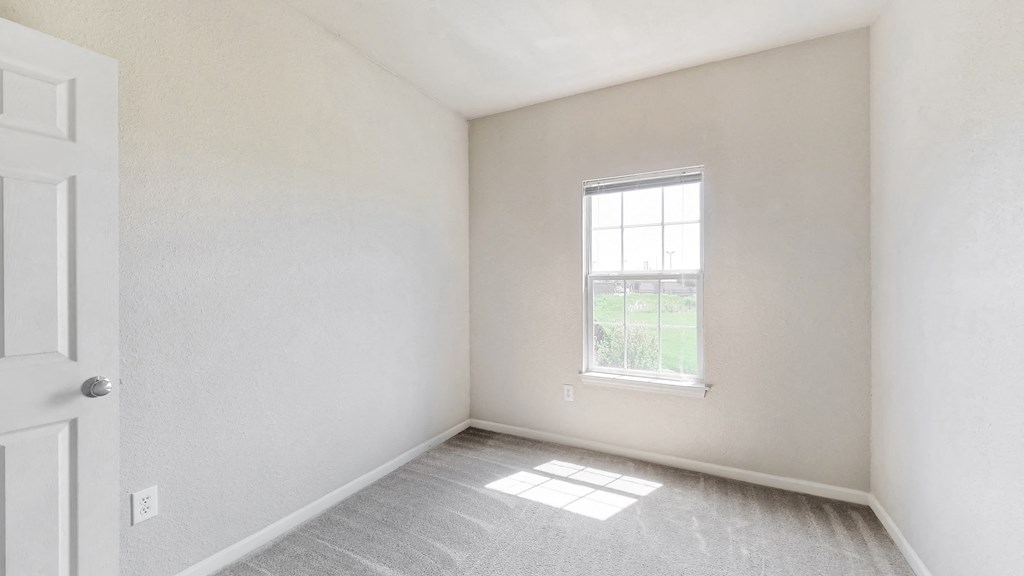 an empty room with white walls and a window