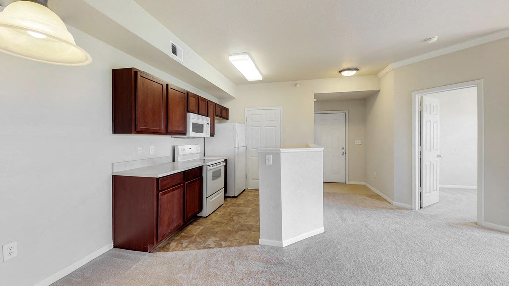 a kitchen with white appliances and brown cabinets and a white door