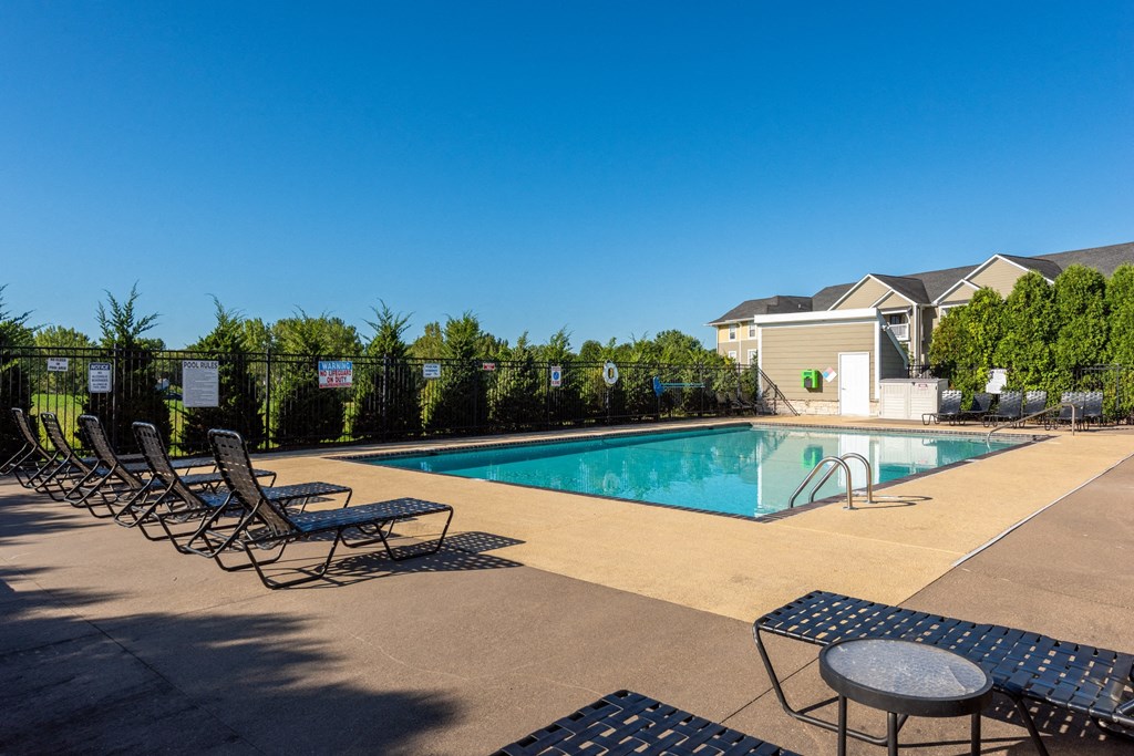 our resort style swimming pool is next to our building with lounge chairs and tables