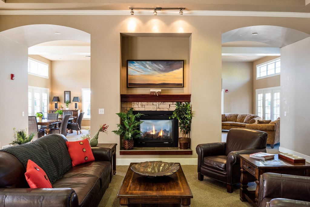 a living room with a fireplace and leather furniture