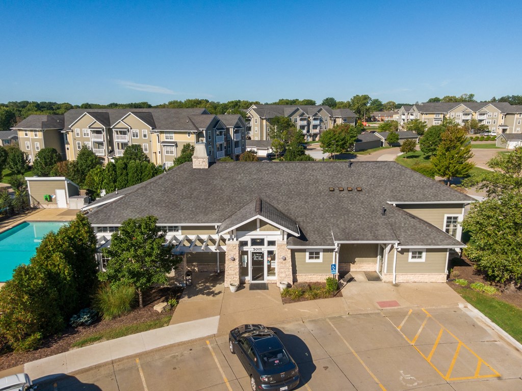 an aerial view of a building with a swimming pool and other buildings
