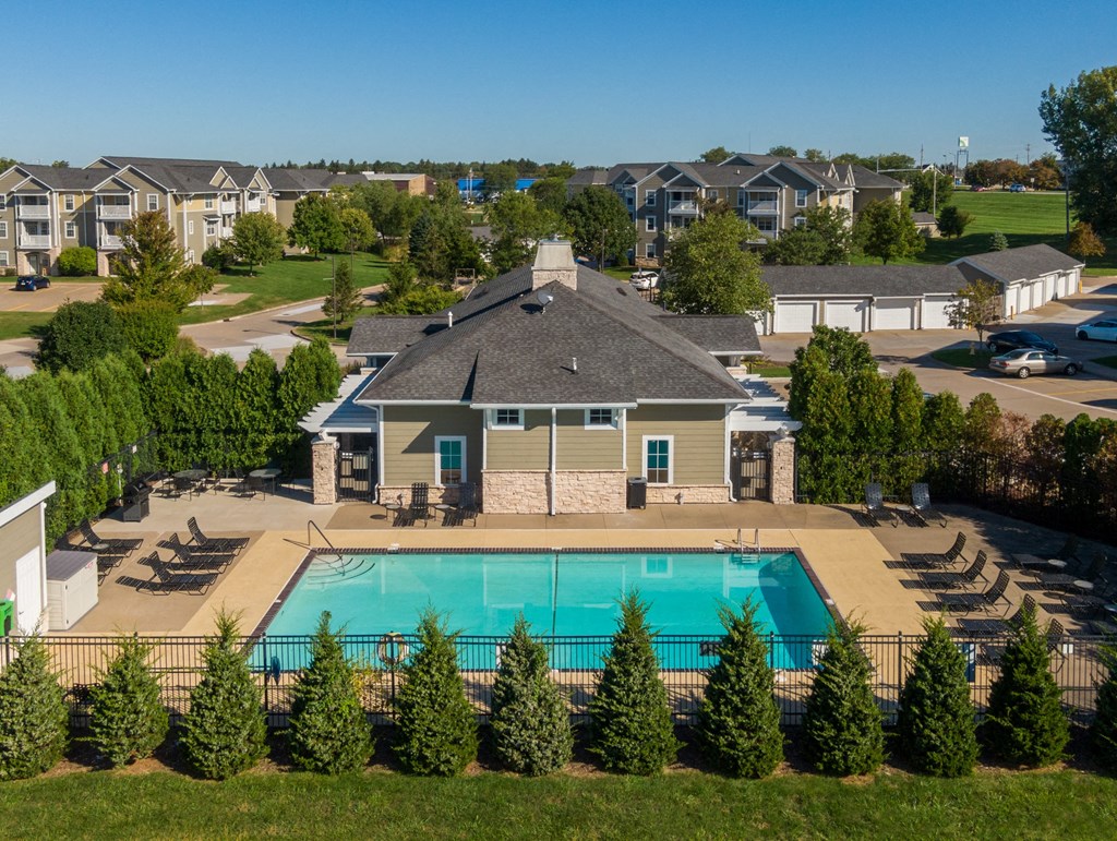 an aerial view of a swimming pool with a building in the background