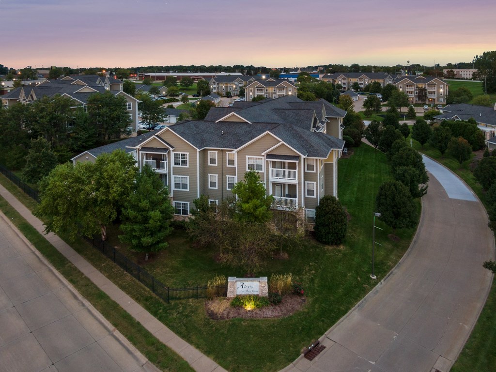 an aerial view of a large house in a neighborhood with a road and other houses