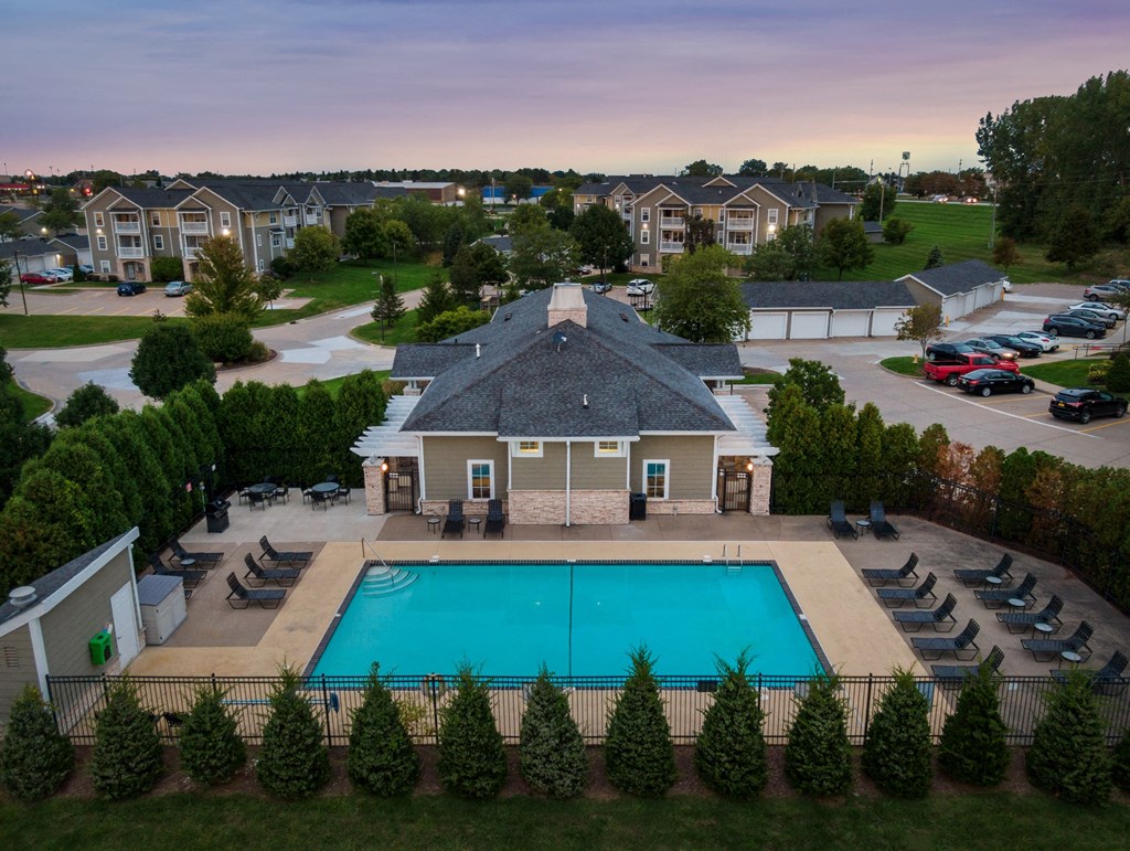 an aerial view of a swimming pool in front of a house
