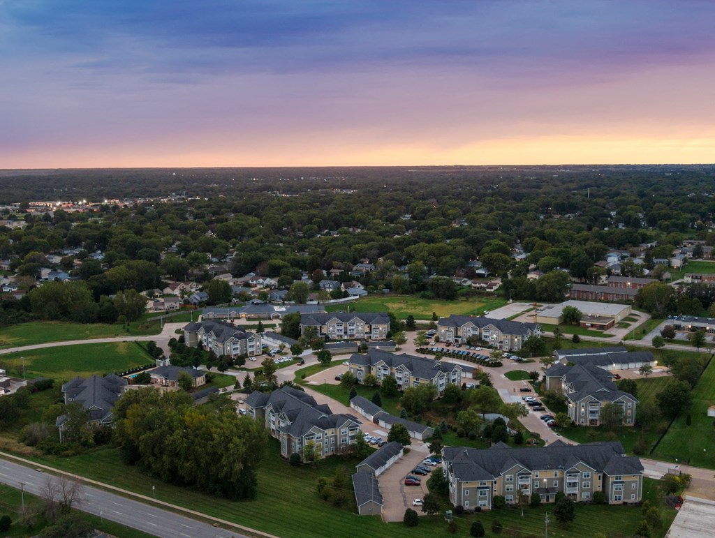 an aerial view of a neighborhood of houses at sunset
