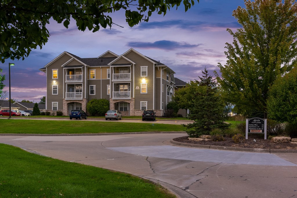 an apartment building with lights on in the evening