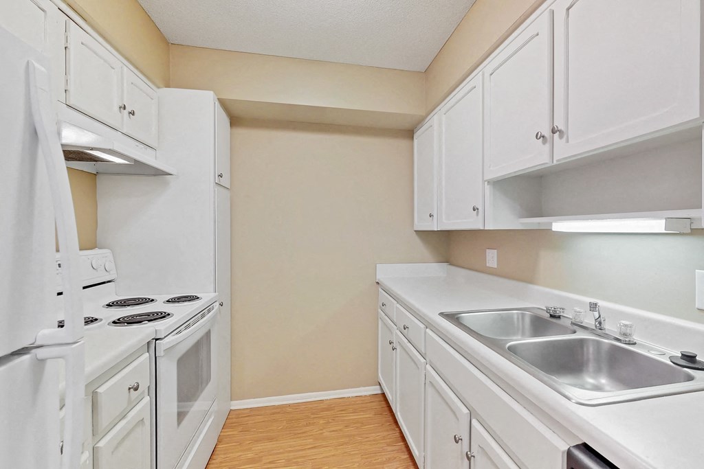 a kitchen with white cabinets and appliances and a sink