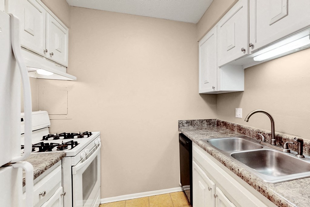 a kitchen with white cabinets and a stove and sink