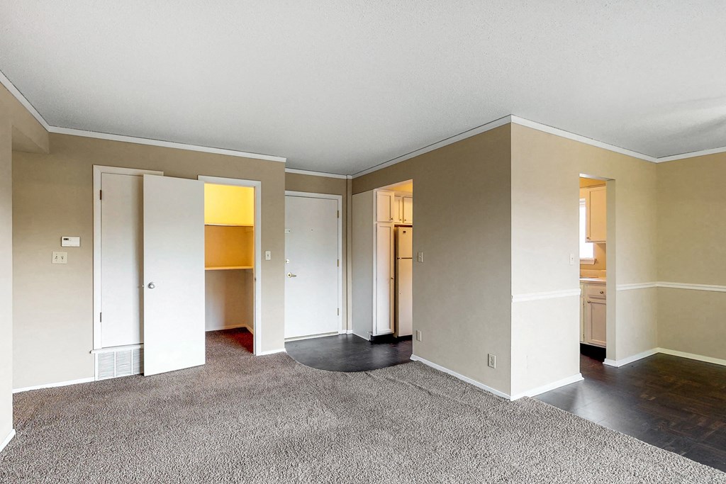 an empty living room with white walls and a carpet