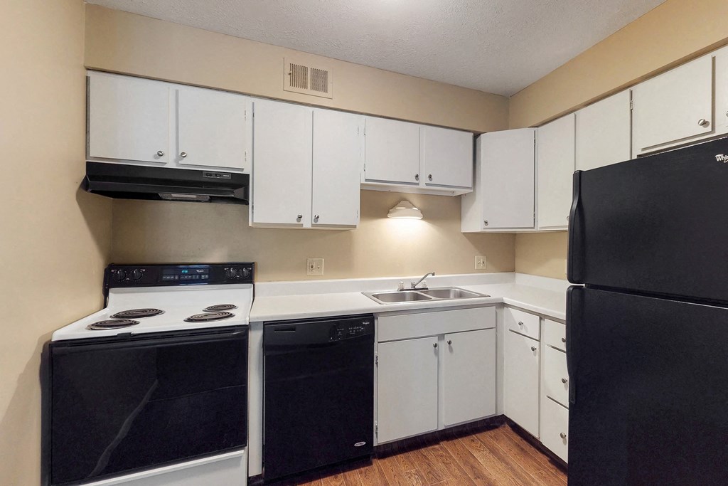 a kitchen with black appliances and white cabinets