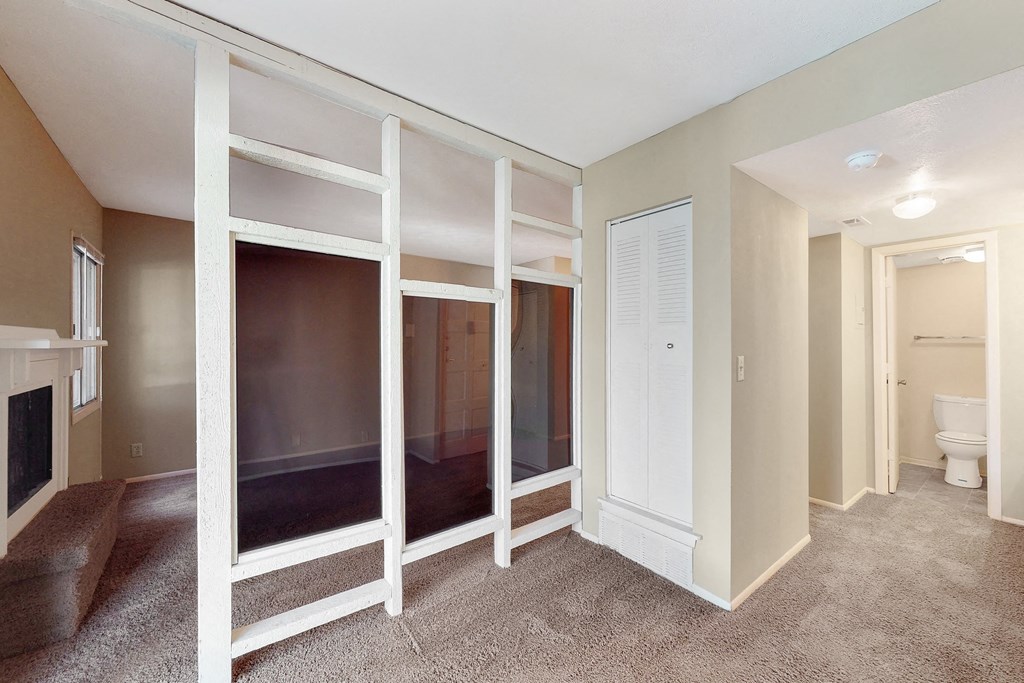 a walk in closet with mirrored sliding doors in a renovated living room