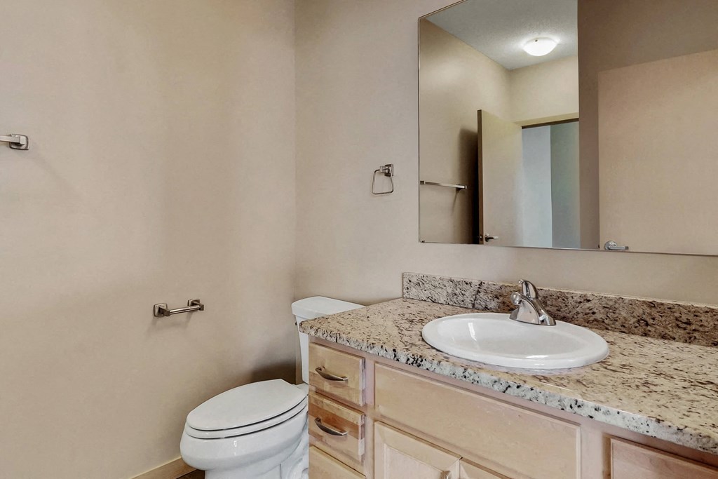 a bathroom with a sink toilet and a mirror