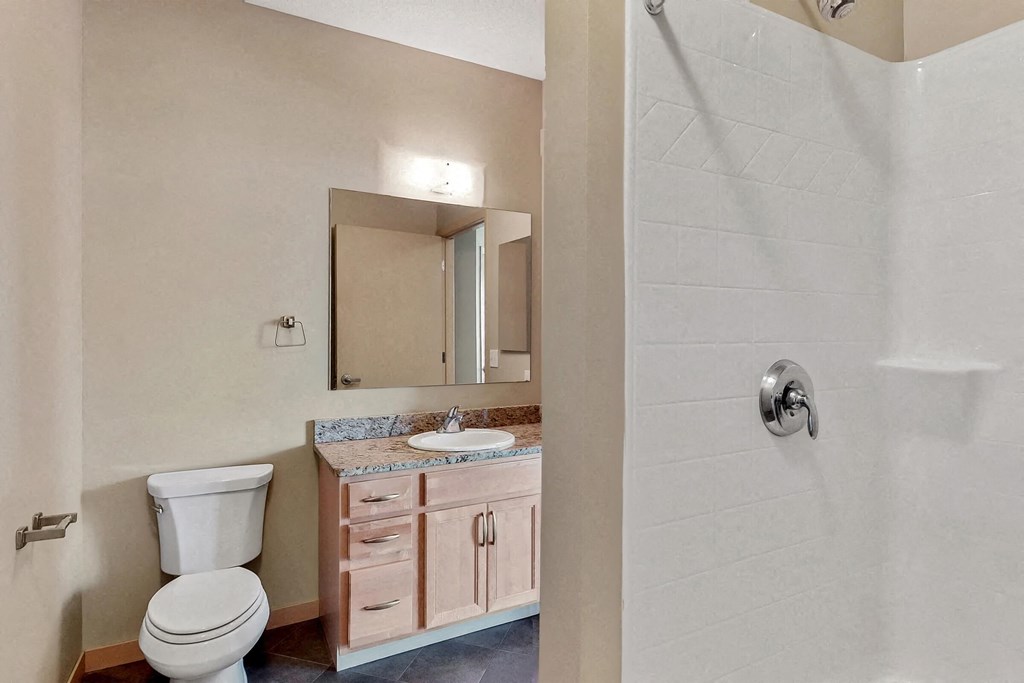 a bathroom with a toilet and a sink and a shower