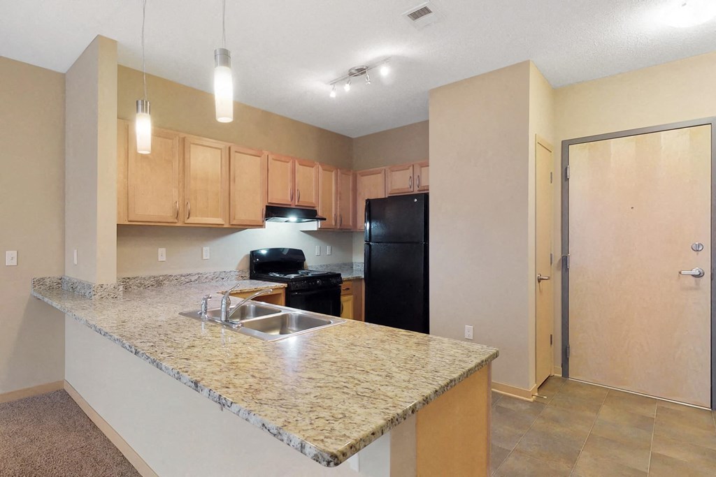 a kitchen with a granite counter top and a black refrigerator