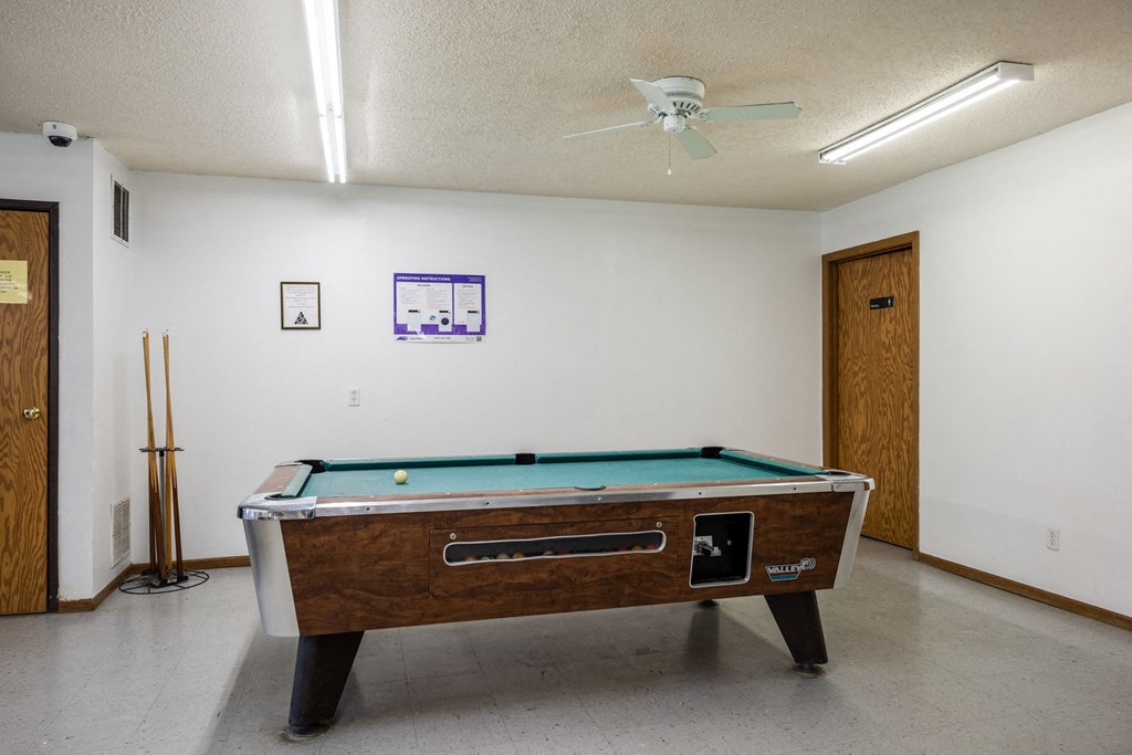 a game room with a pool table and a ceiling fan