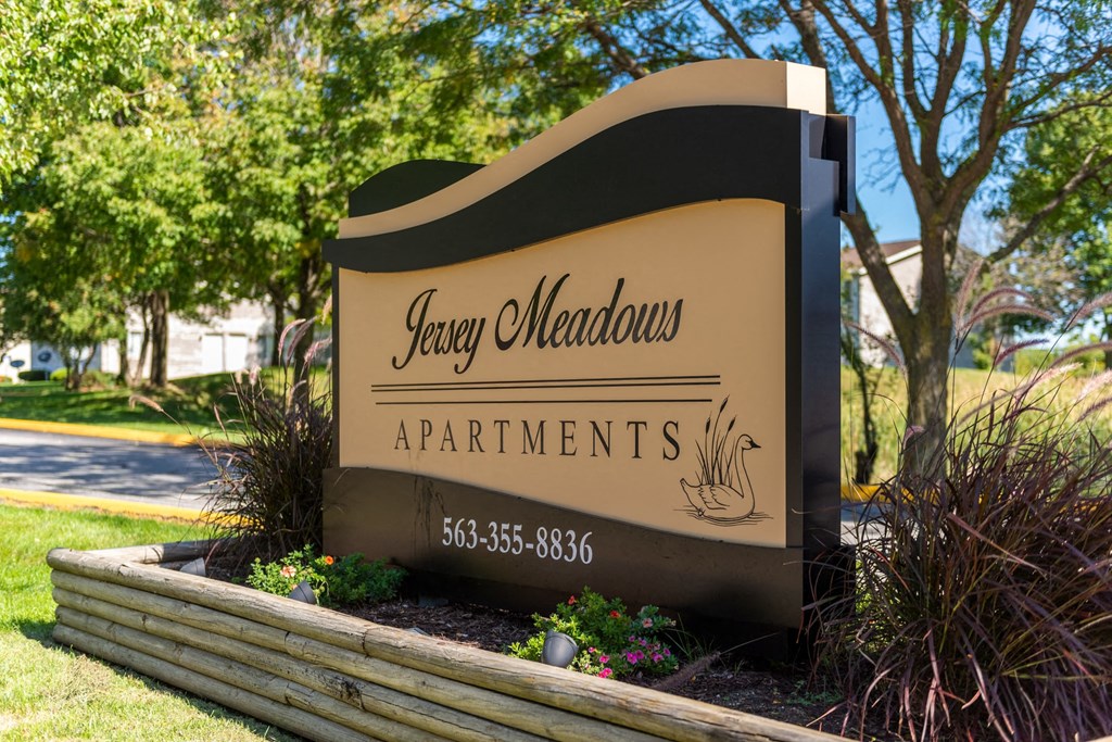 a sign allocations apartments in front of a tree