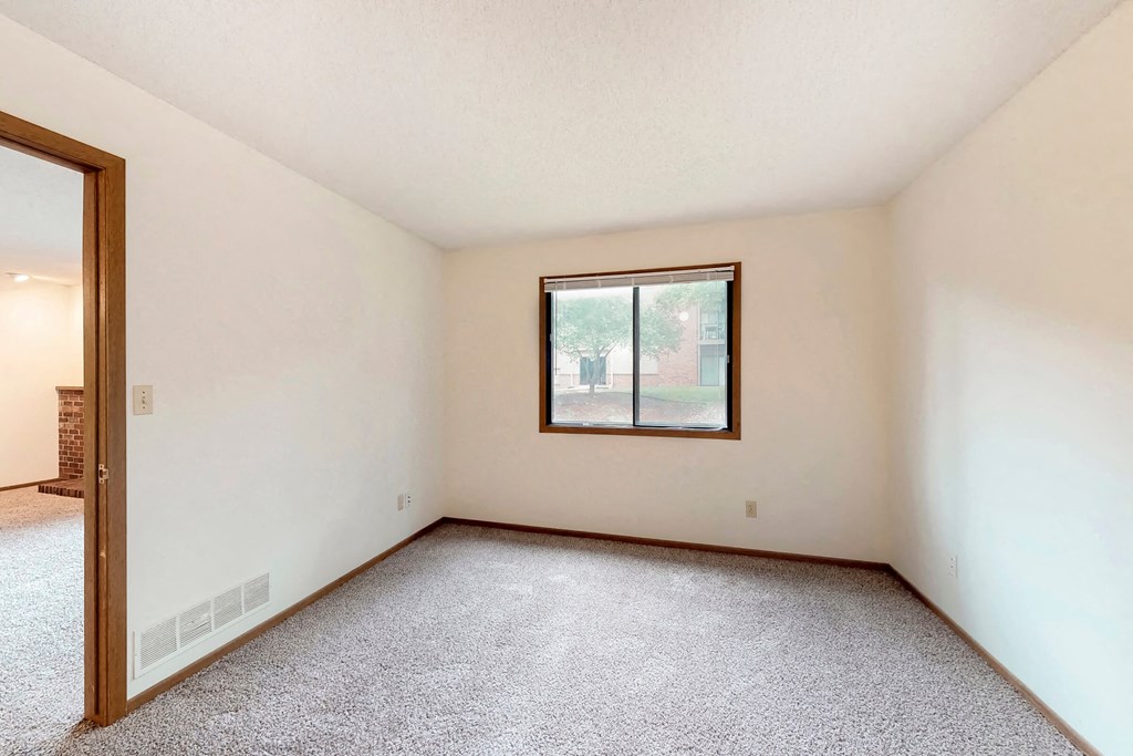 an empty room with a window and a door