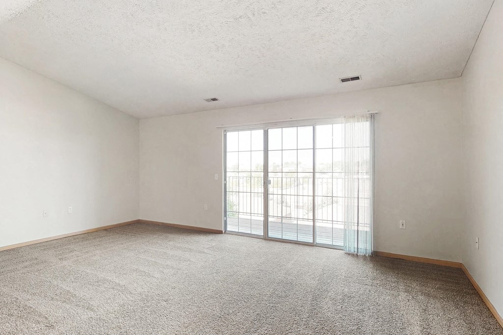 an empty living room with a sliding glass door