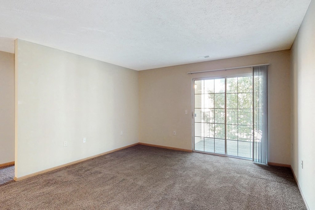 an empty living room with a sliding glass door