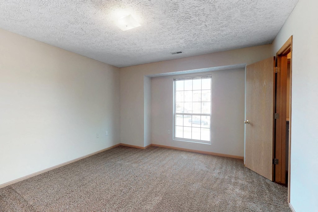 an empty room with a window and a door