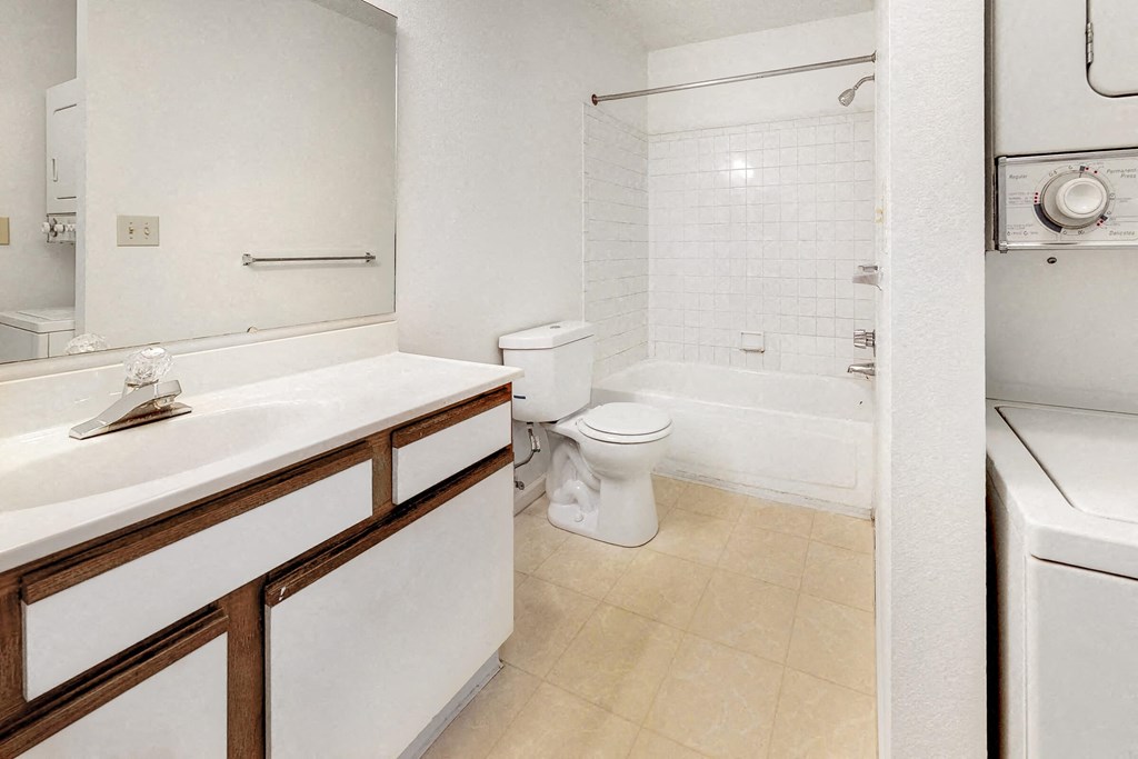 a bathroom with a toilet and a tub and a sink