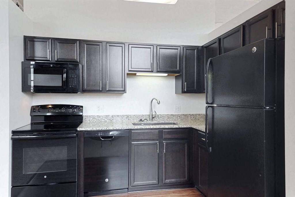 a kitchen with black appliances and granite counter tops