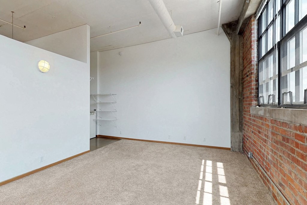 an empty room with large windows and a white wall