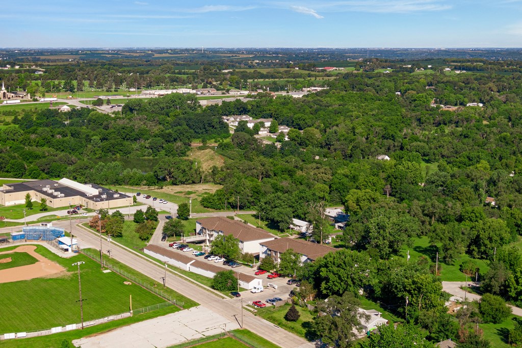 an aerial view of a neighborhood with trees and houses and a road
