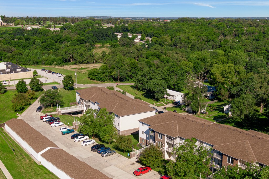 an aerial view of a building with cars parked in a parking lot